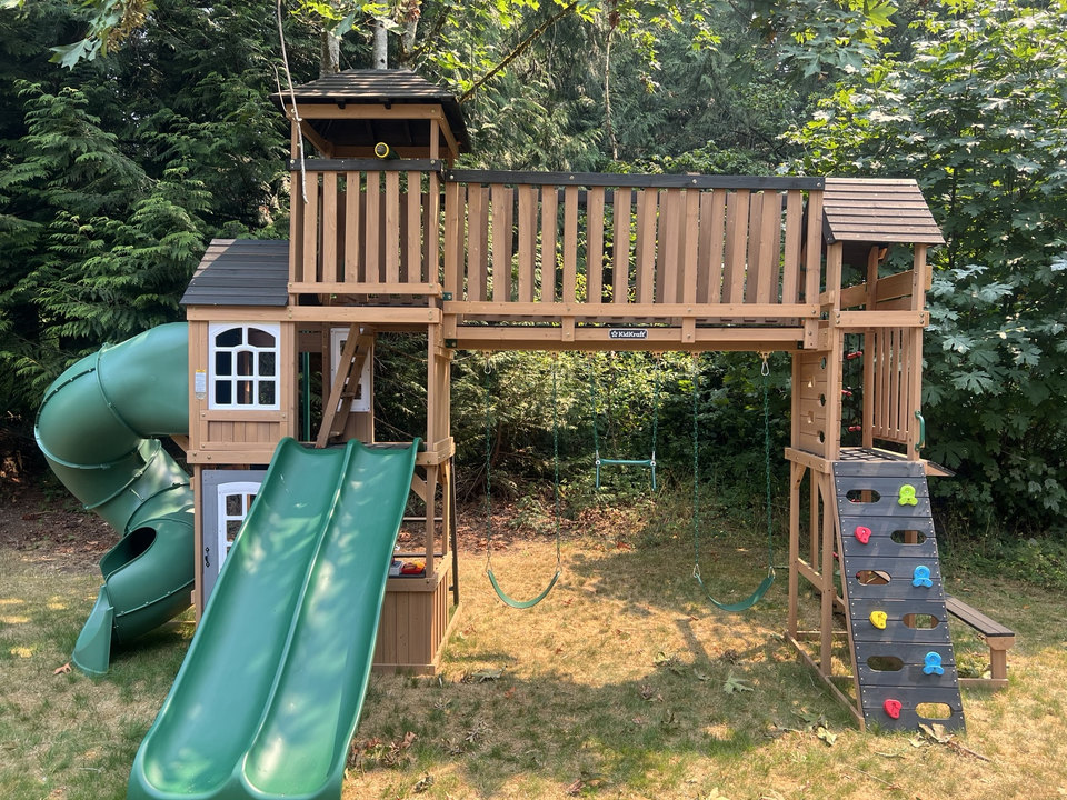 Wooden outdoor playset with a bridge and slides