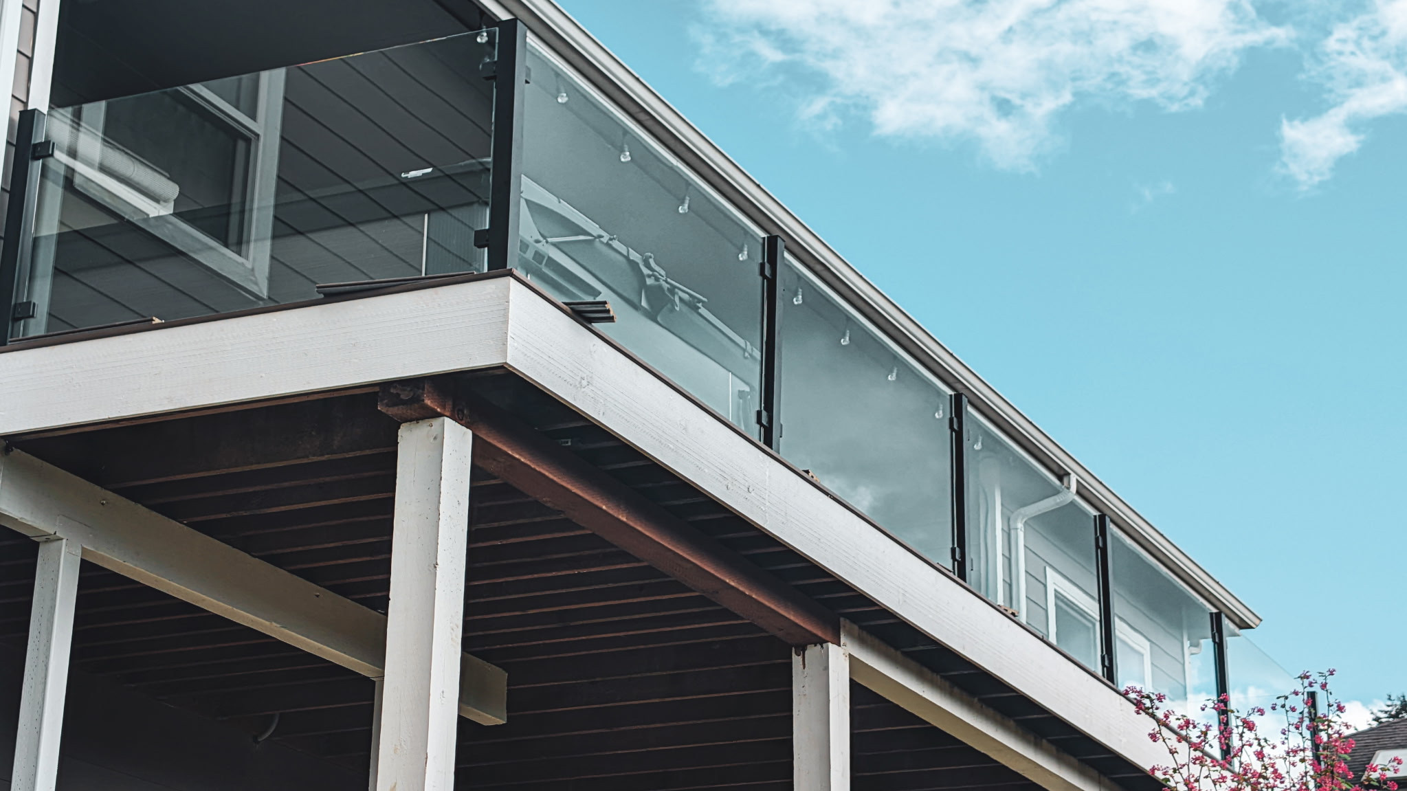 Glass railing panels with dark posts along an elevated exterior deck