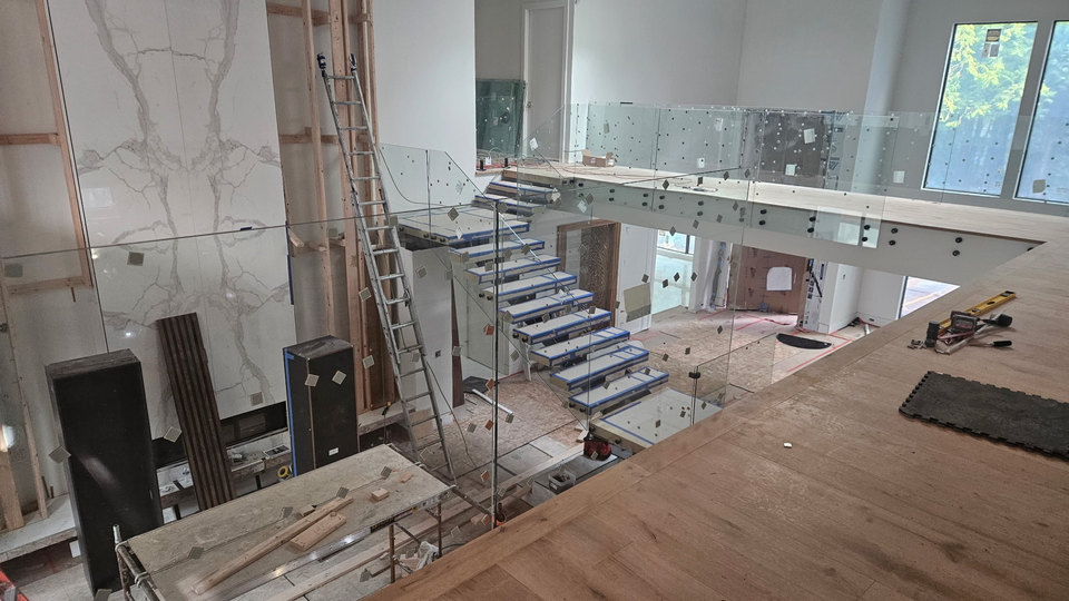 Another view of the same in-progress interior glass-railing project around stairs