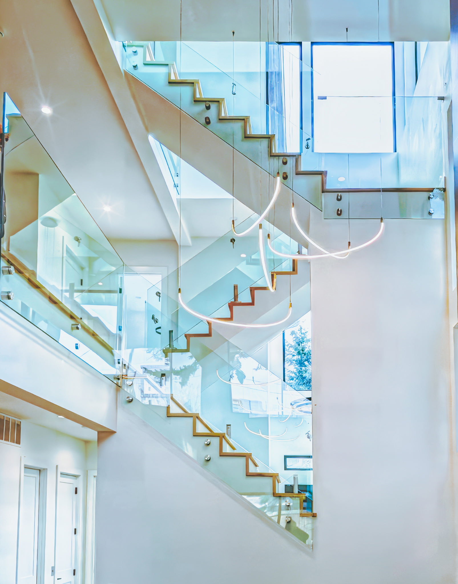 Clear glass railings along multiple indoor stair flights