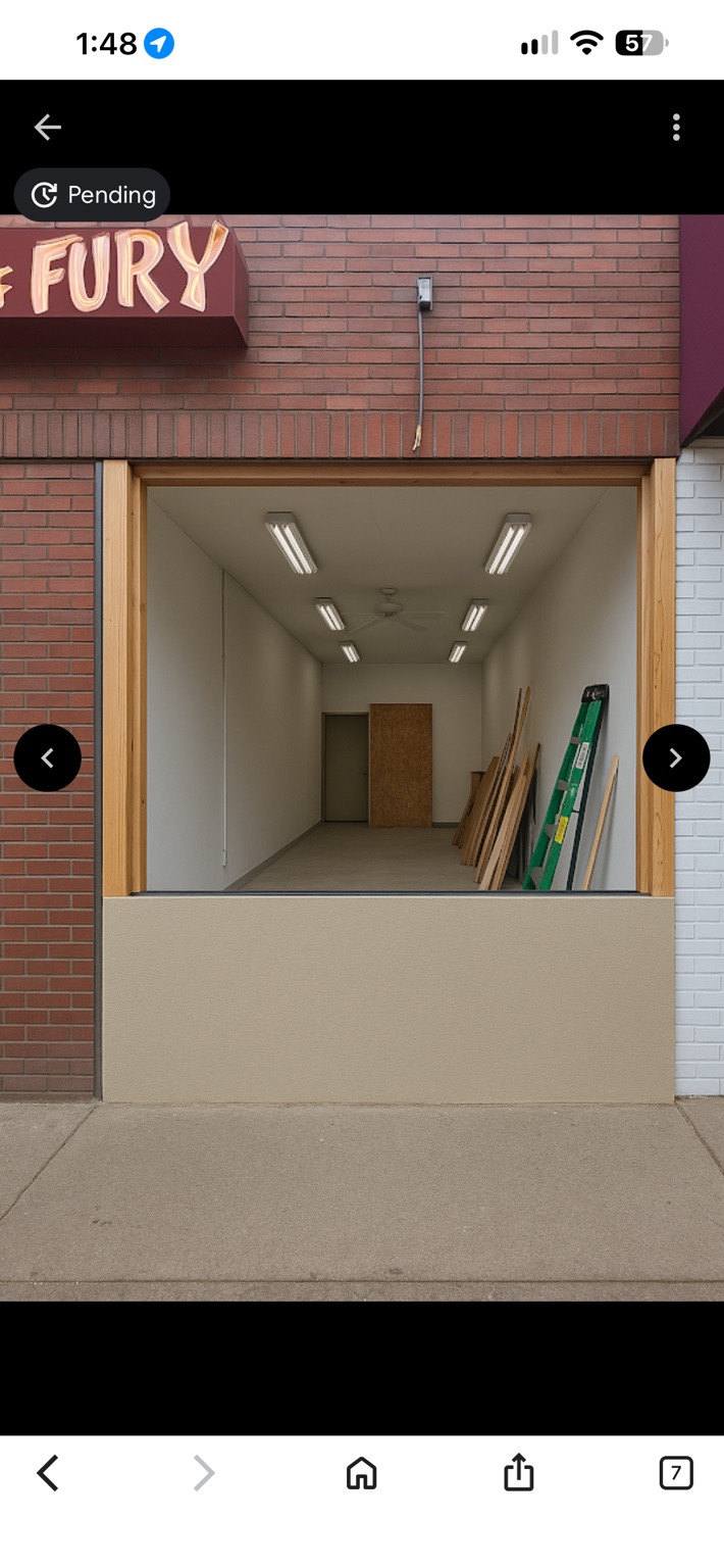 Storefront opening with timber framing, a ladder and materials visible