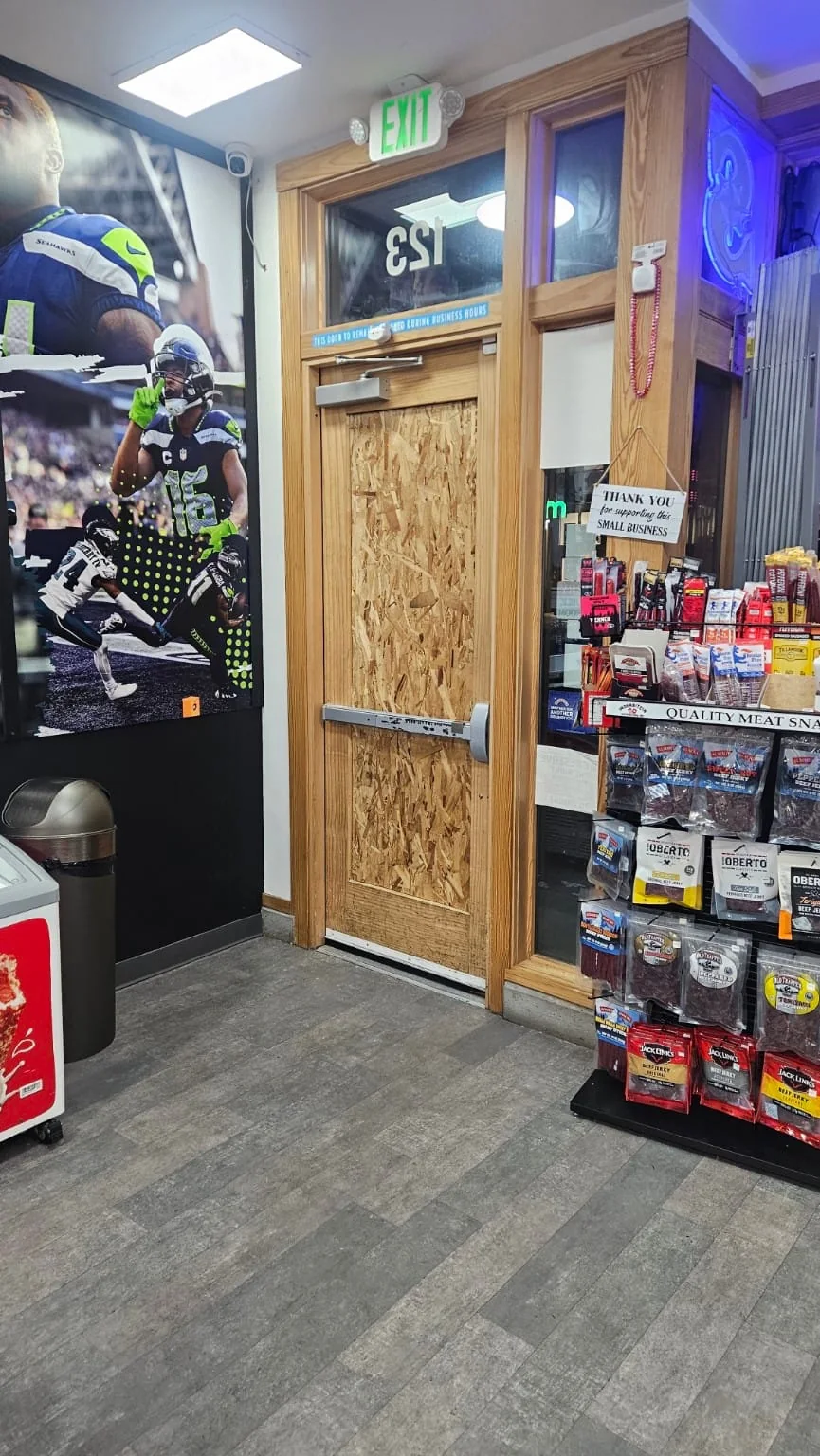 Interior shop entry door protected with wood panels around existing hardware