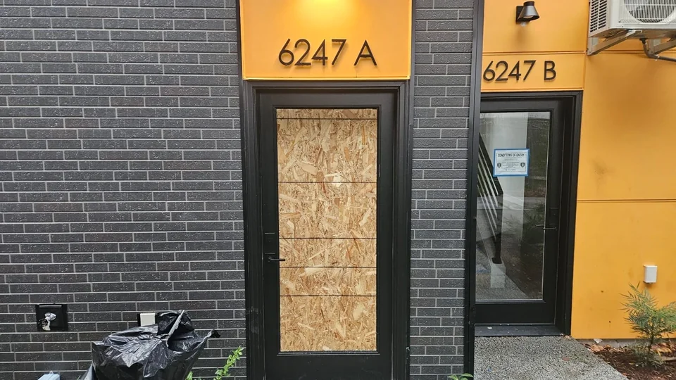 Exterior doorway in a brick and yellow facade protected with fitted wood panels